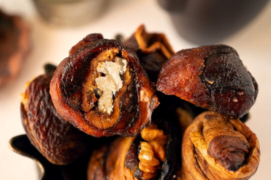 Syrian sweets are served on the table. A mixture of Arabic sweets and dates of hastac. Dried fruit rolls stuffed with walnuts close-up. Selective focus. Small depth of field