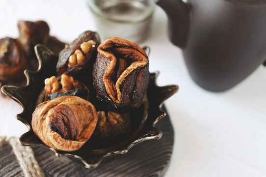 Syrian sweets are served on the table. A mixture of Arabic sweets and dates of hastac. Dried fruit rolls stuffed with walnuts close-up. Selective focus. Small depth of field