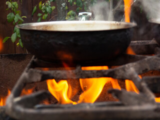 frying pan on a bright fire. cooking in the fresh air. burning grill