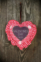 Red and white heart on a weathered wood and valentines day and the german word valentinstag