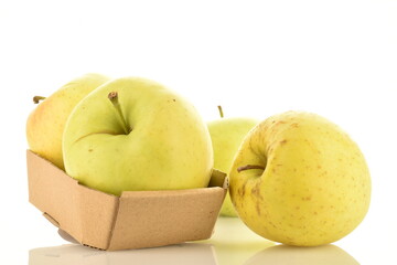 Several fresh yellow apples with a paper box, close-up, isolated on white.