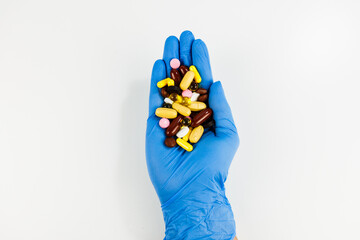 pills in hand in gloves on white background