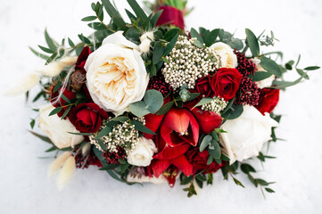 Fototapeta na wymiar Wedding bouquet of red and white roses flowers on the white snow