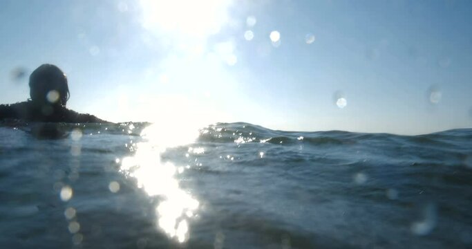 Long-haired man in dark clothes quickly runs into the sea to drown.  The concept of lost hope and suicide. 4k slow motion