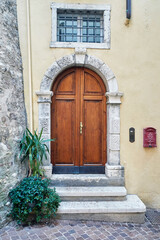 Italian retro wood style front door, the main entrance. Element of the classic Italian facade and architecture