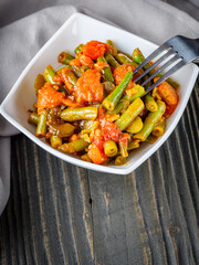 stewed green beans on a dark wooden rustic background