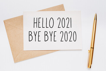 hello 2021 bye bye 2020 note with envelope and gold pen on white background. merry christmas and...
