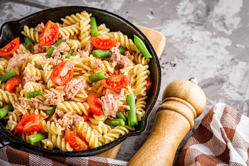 delicious traditional Italian pasta with tuna on a dark rustic stone background