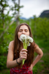 Obraz premium Girl with dandelion on green field