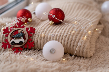 Christmas decorations on a warm sweater. There are a lot of lights on at Christmas. © Arina Surovenko