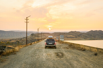 4wd car drive on gravel road towards the sunset in VAshlovani national park