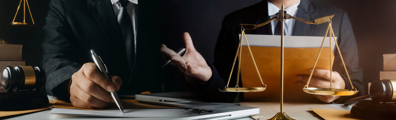 Business and lawyers discussing contract papers with brass scale on desk in office. Law, legal services, advice, justice and law concept picture with film grain effect