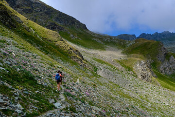 Obraz premium Young friends boys and girls walk in the mountains, along paths trought rocks and nature. 