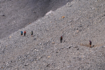 Young friends boys and girls walk in the mountains, along paths trought rocks and nature. 