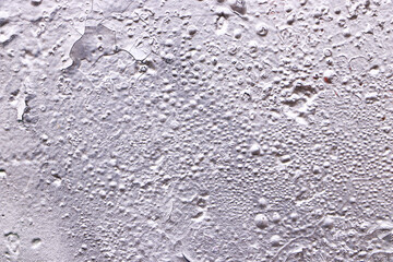 Texture of a gray wall with aged paint. Empty plain silver background.