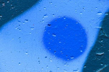 Blue concrete wall with paint circles. Empty abstract grunge background.