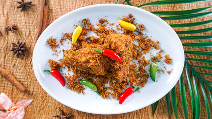 chicken serundeng from coconut fried with chilies served on white plate ready to eat