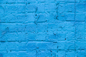 Old brick wall close-up covered with light blue paint. Empty backdrop. 