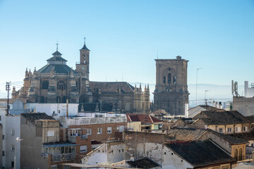 Fototapeta na wymiar Cathedral and its bell tower behind the roofs of old houses in the city