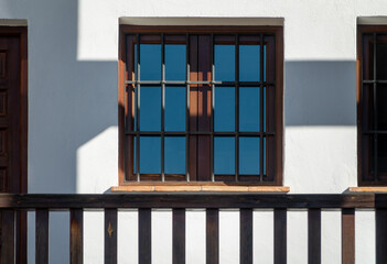 Window between wooden beams in a white facade house
