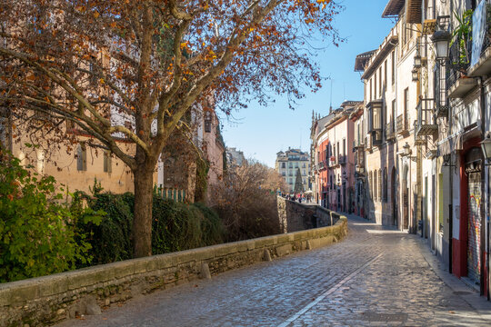 A walk in Granada: View of the Paseo de los Tristes next to the Darro river with Plaza Nueva in the background