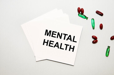 On the notes, the text of Mental Health, next to the green and red capsules.