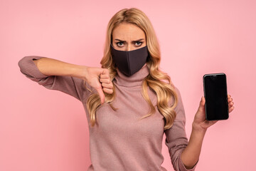 Young girl in pink blouse, face mask isolated on pink background. Epidemic pandemic coronavirus...