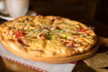 Pizza on the table in a cafe, fast food, eating and people concept - close up