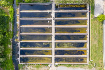 Fish ponds in an aquaculture farm - farming enclosures with fresh water where trout, carp or salmon is raised commercially for food. Aerial top view of the tanks.