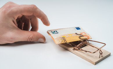 Isolated hands on white background grabbing for mousetrap with 50 euros banknote