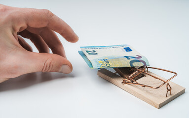 Isolated hands on white background grabbing for mousetrap with 20 euros banknote