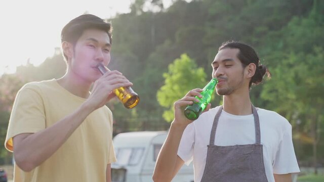 Two travelers clinking beer bottles and drink on holiday trip party.