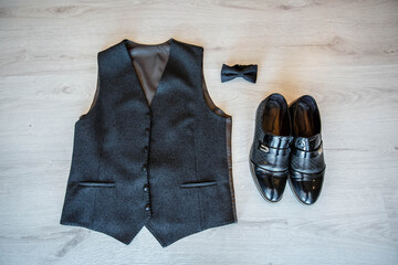 groom's vest, shoes and bow tie on the floor