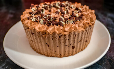 Norwich, Norfolk, UK – December 25 2020. An illustrative editorial photograph of a close up of a frozen double chocolate gateau on a white plate on a marbled black kitchen worktop