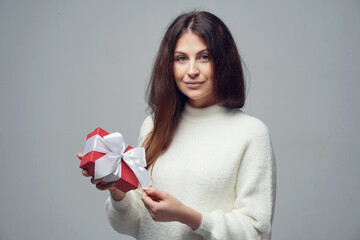 gifts boxes holiday March 8, Valentine's Day, February 14. a woman with brown hair of European appearance. Photo in a photo studio on a gray white background. space to copy.