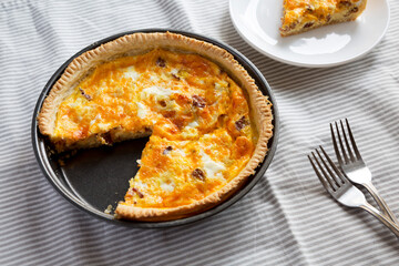 Homemade Bacon Quiche with Eggs and Cheddar Cheese, side view.