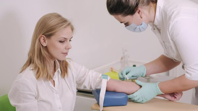 Close up footage nurse insert needle into man vein in order for the person to donate blood. Blood donation.