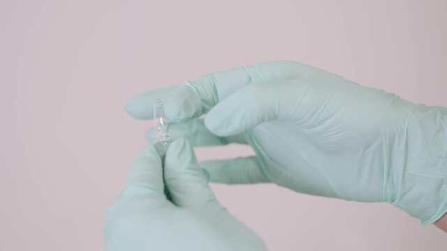 Vaccination concept. Doctor is going to do covid-19 vaccination to a patient. She is opening the ampula.