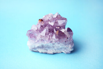 Beautiful druse of natural purple mineral amethyst on a blue background. Large crystals of a gem.