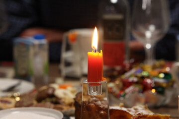 A burning candle on a festive table
