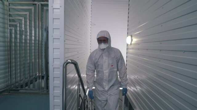 workers in protective suits walk through the factory