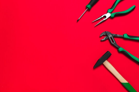 A set of quality green building tools to repair a car or a house on a red background. Do it yourself instruments. Banner for advertising construction shop with copy space. Business card