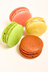 Delicious multicolored macaroons on white background.