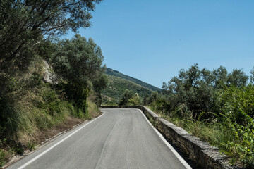 Mountain road view with medieval city on the background on a beautiful summer or spring sunny day with blue sky