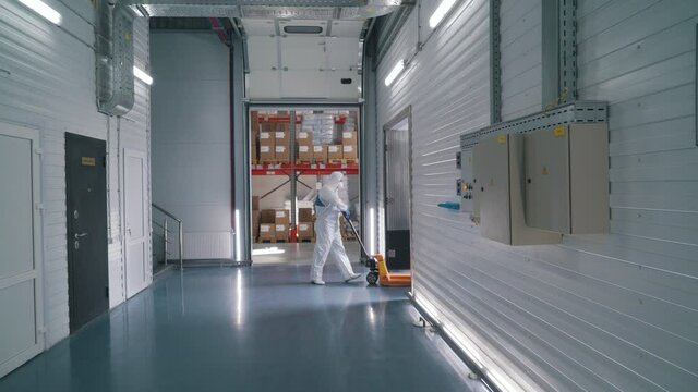 worker uses a stacker to transport goods in a warehouse