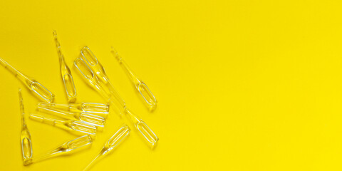 Ampoules, vaccine isolated on yellow background. Top view. Banner. Stop coronavirus. Medical and health care concept.