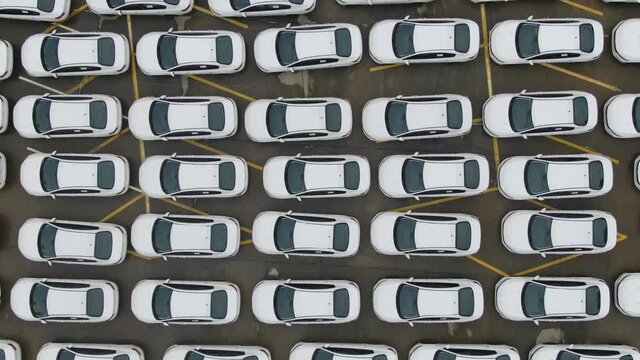Aerial top view of new cars parking for sale stock lot row, dealer inventory import and export business commercial worldwide, Automobile and automotive industry distribution logistic global transport 