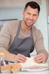 handsome man standing smiling make pizza in kitchen
