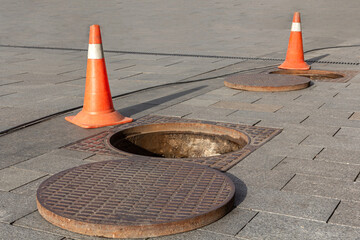 Manhole cover open in street and repair of roads. Accident with sewer hatch in city. Concept of...