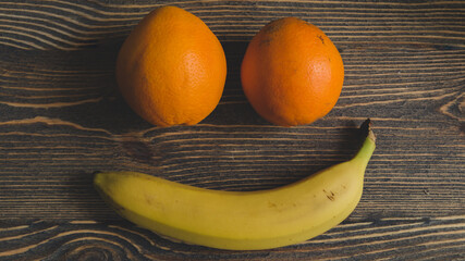 Orange and banana on a wooden background